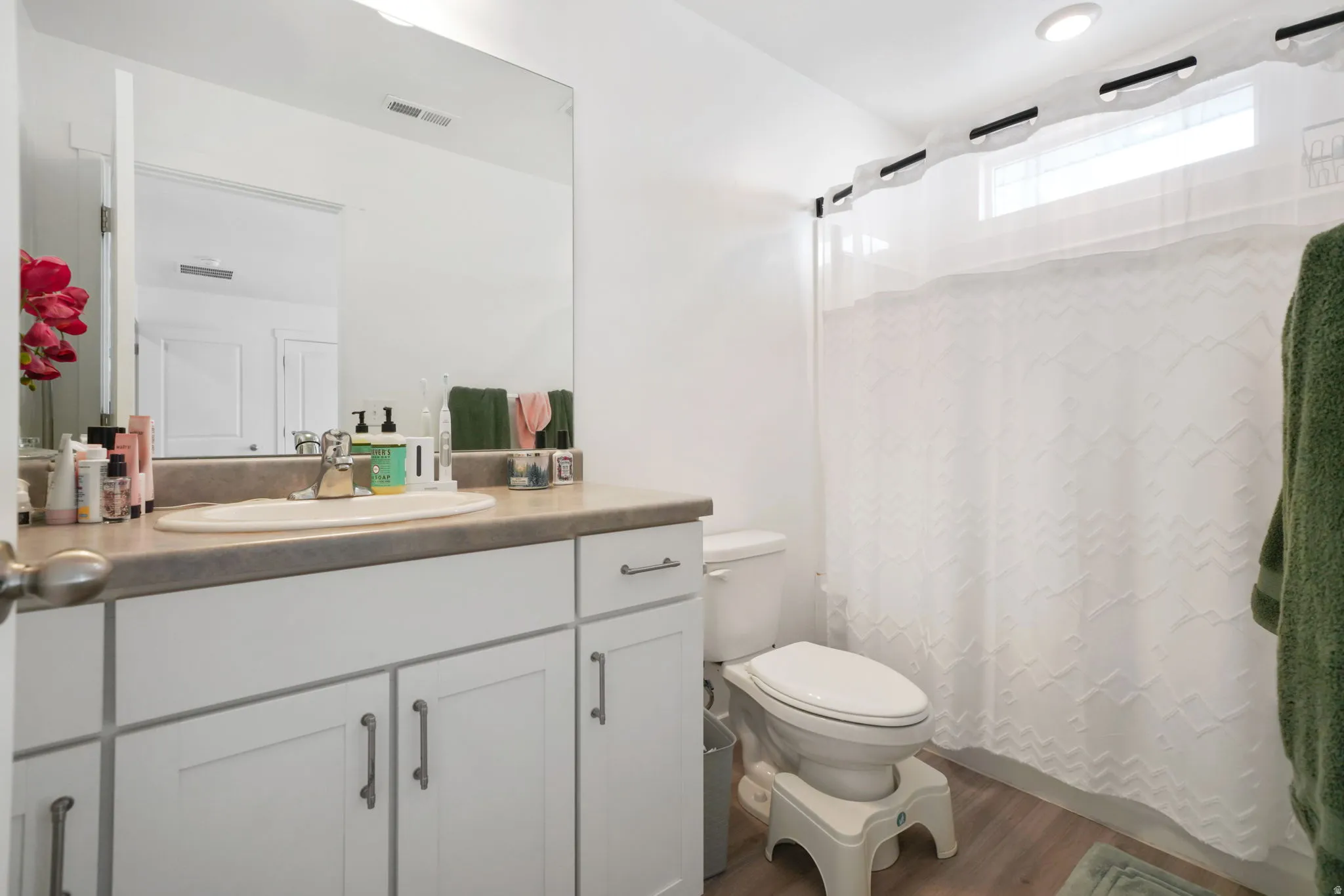 Full bath with a shower with shower curtain, vanity, and dark wood-type flooring