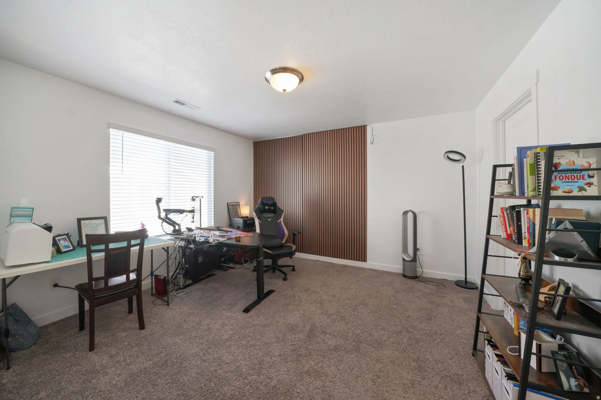 Office area featuring light colored carpet and baseboards