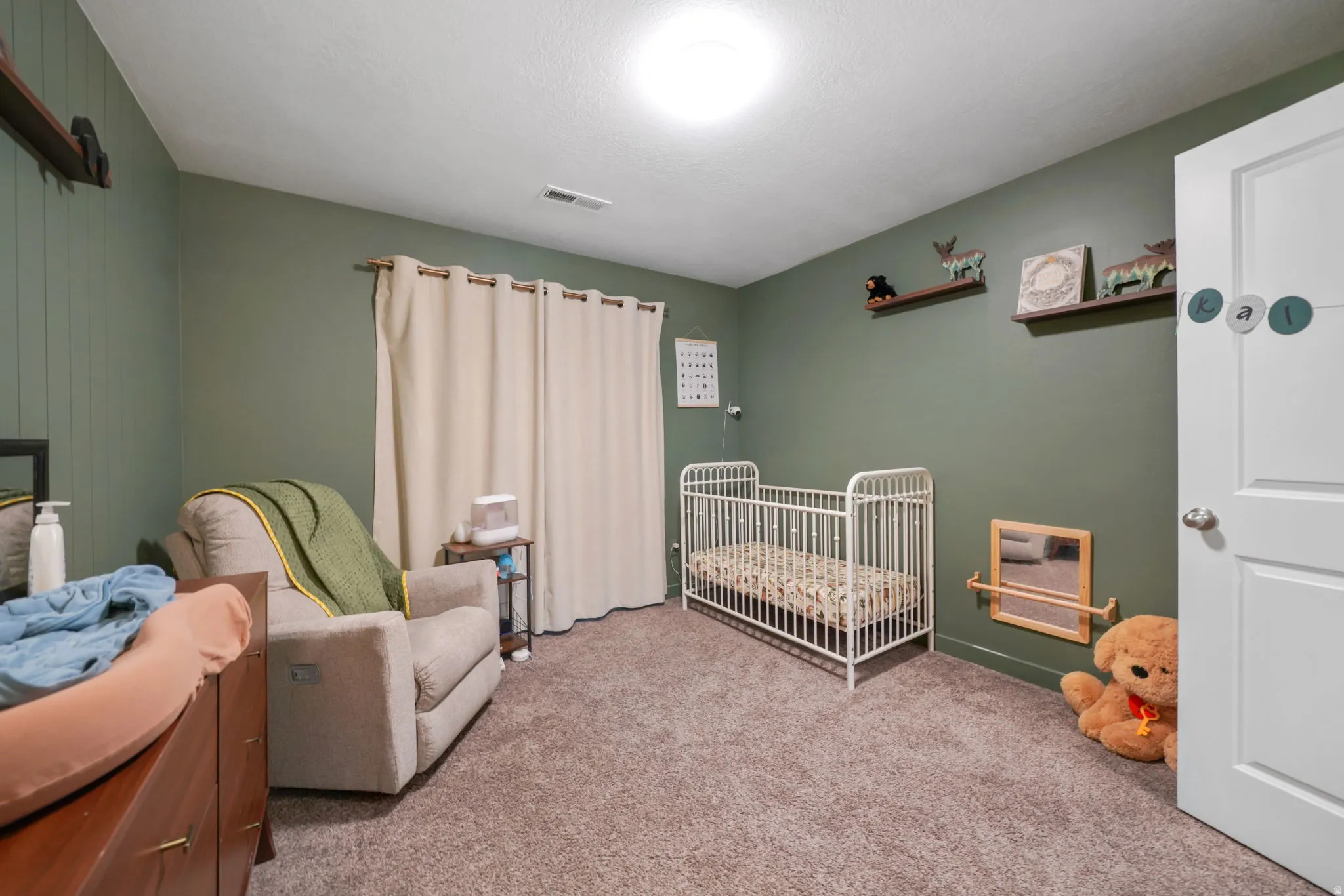 Carpeted bedroom with a crib