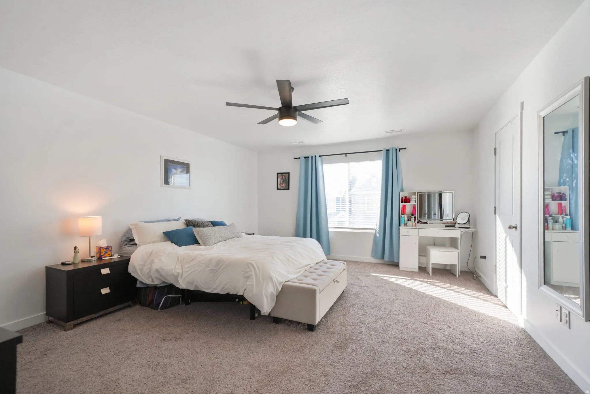 Bedroom with light colored carpet and ceiling fan