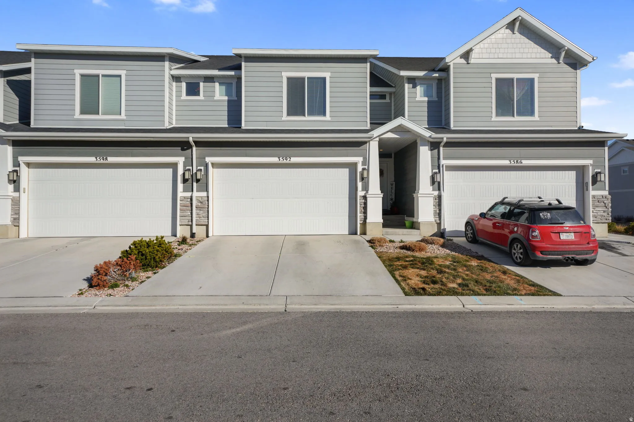 View of front of house featuring an attached garage, stone siding, and concrete driveway