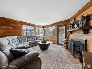 Living room featuring wood walls and a fireplace with flush hearth