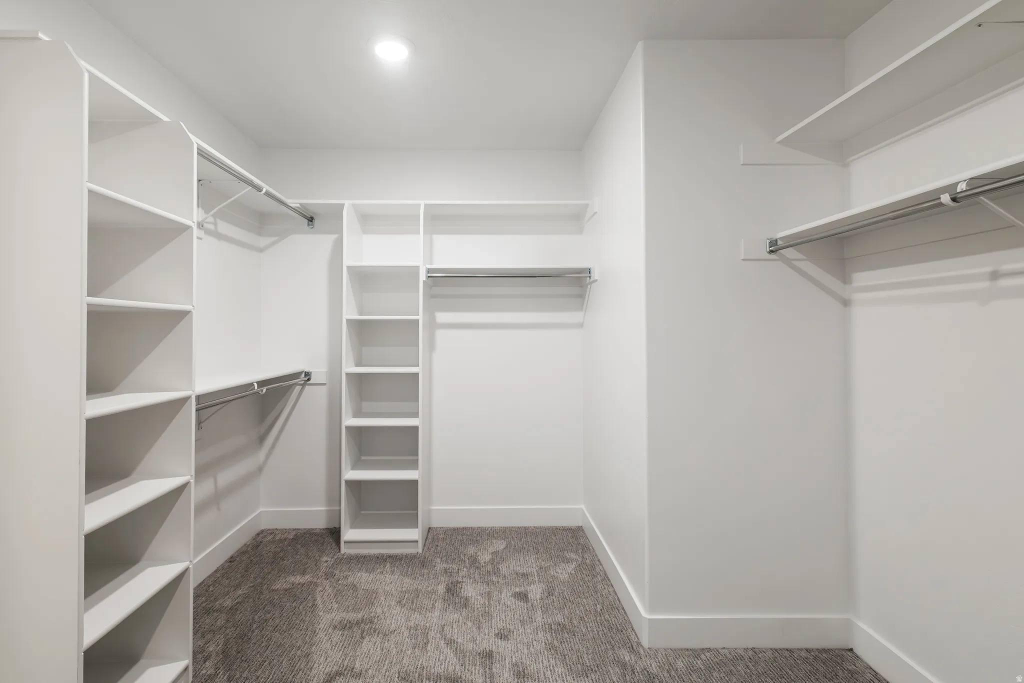 Walk in closet featuring dark carpet