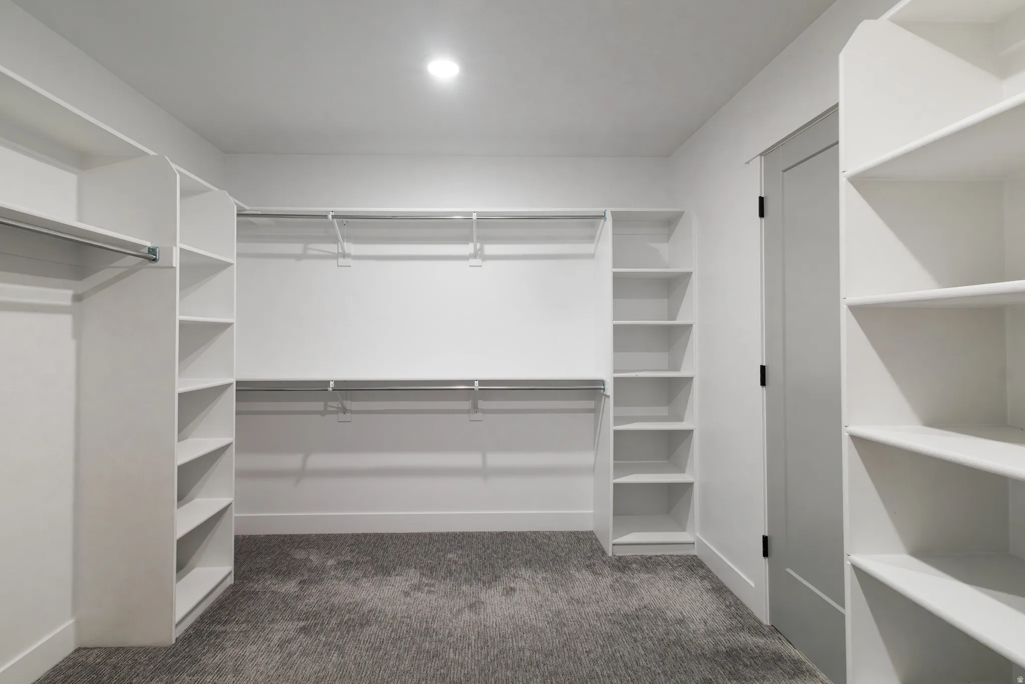 Walk in closet featuring dark carpet