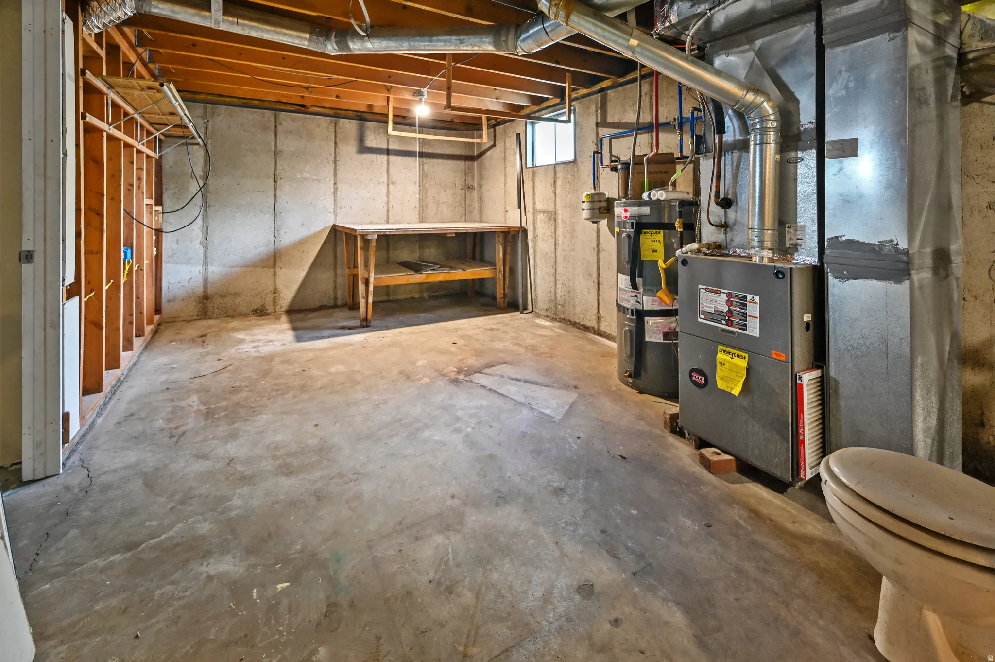 Basement featuring water heater and heating unit