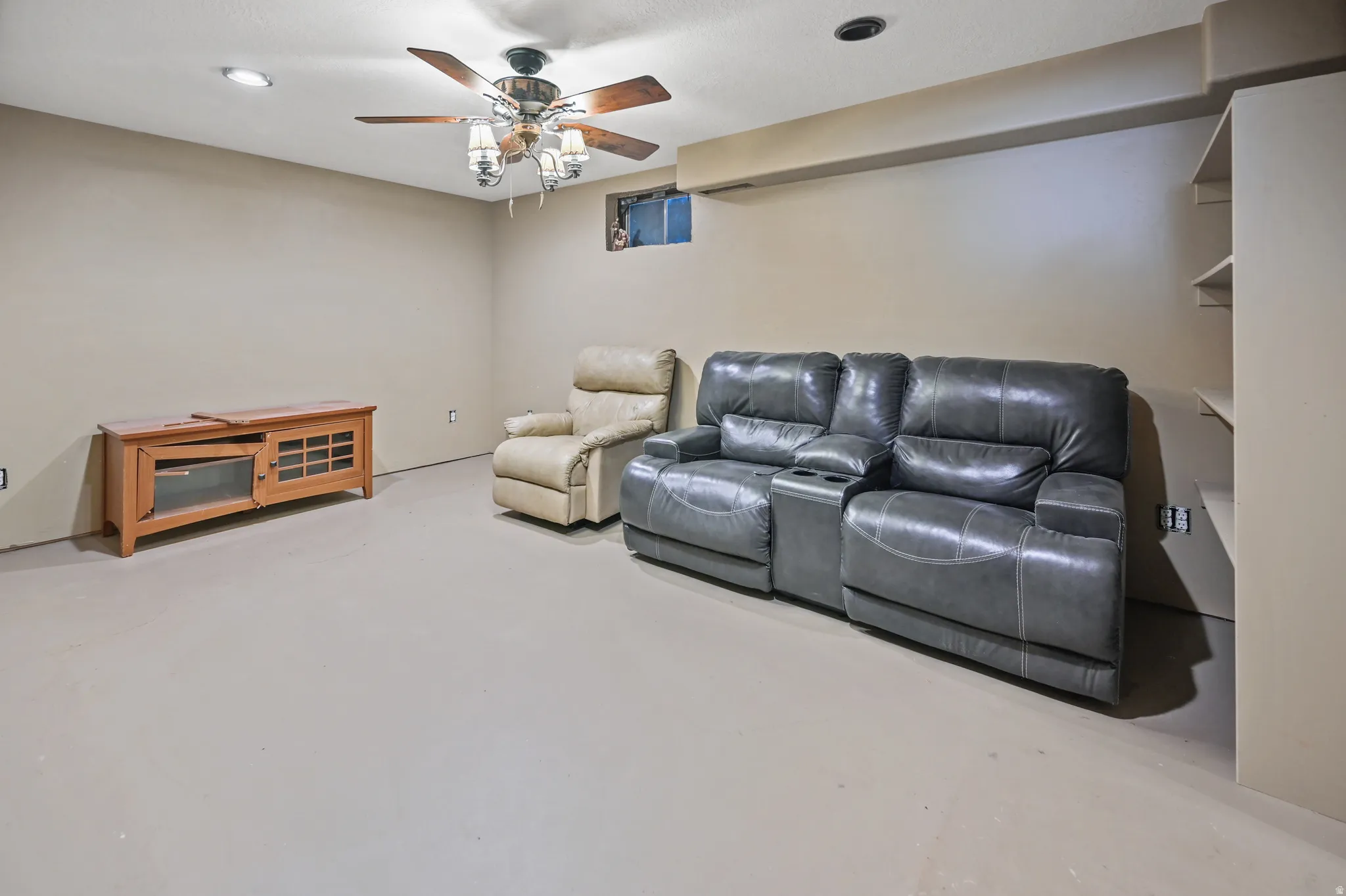 Cinema featuring concrete flooring, ceiling fan, and recessed lighting