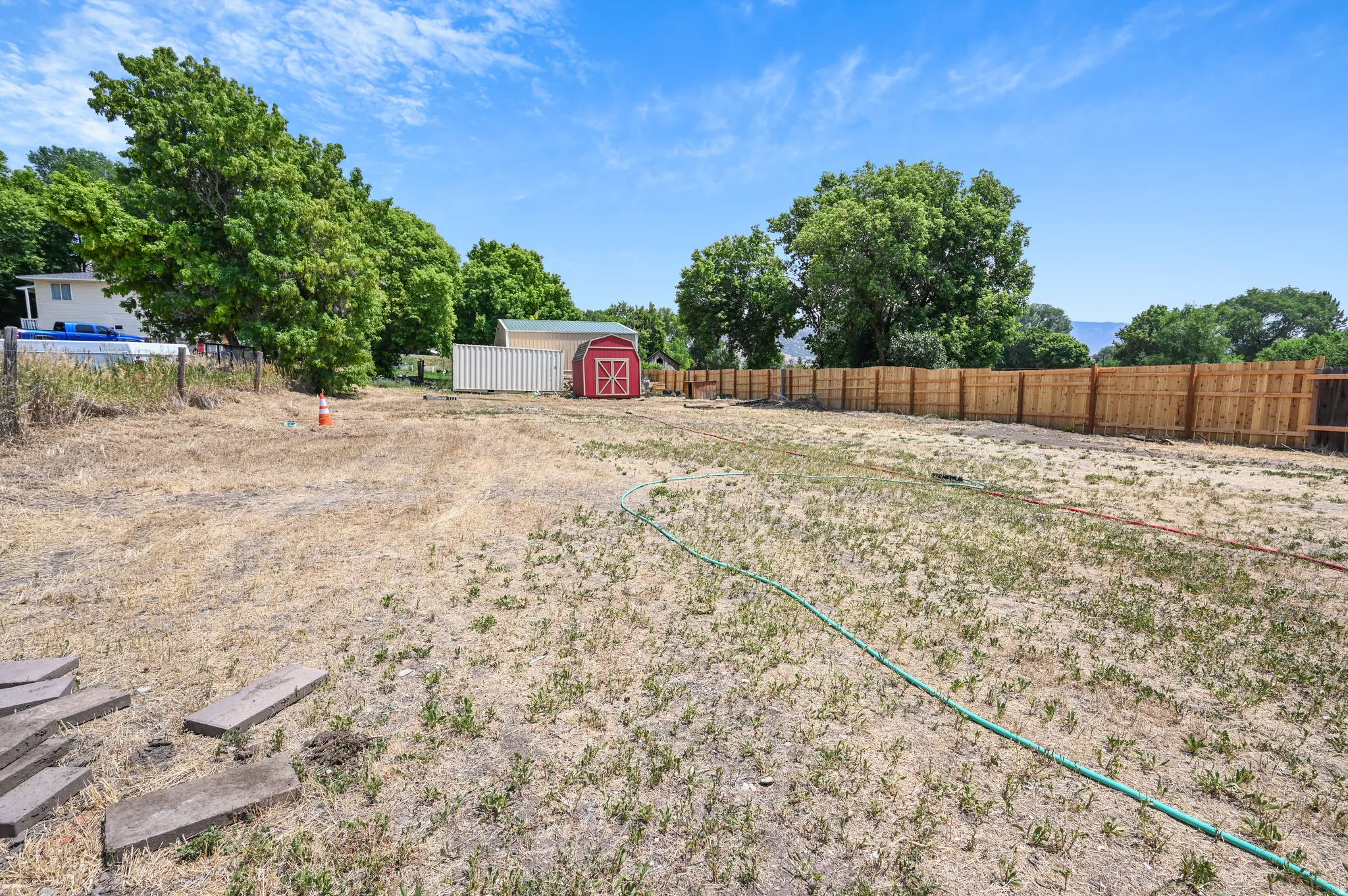 Fenced backyard featuring a storage shed