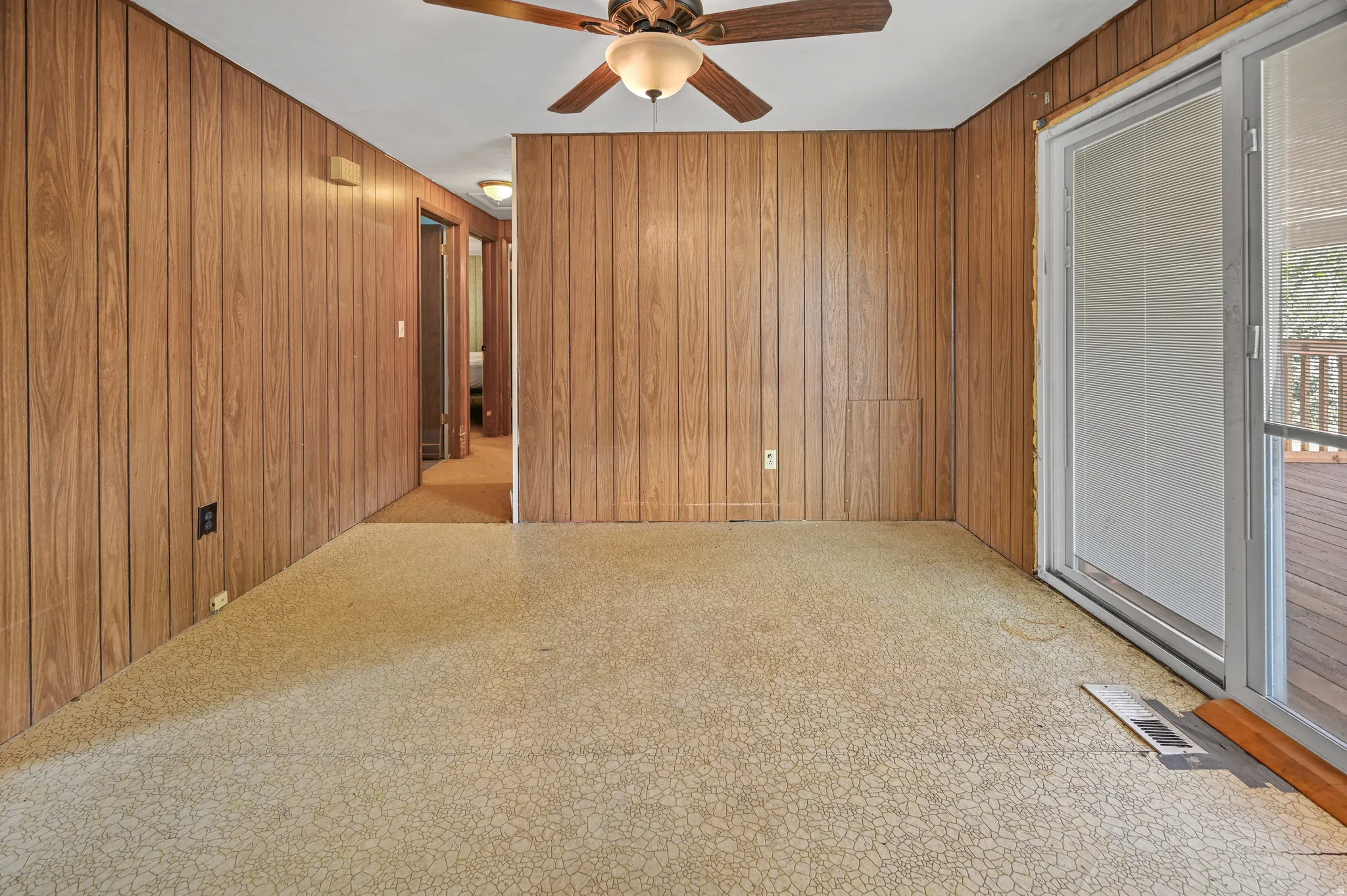 Spare room featuring a ceiling fan and wooden walls
