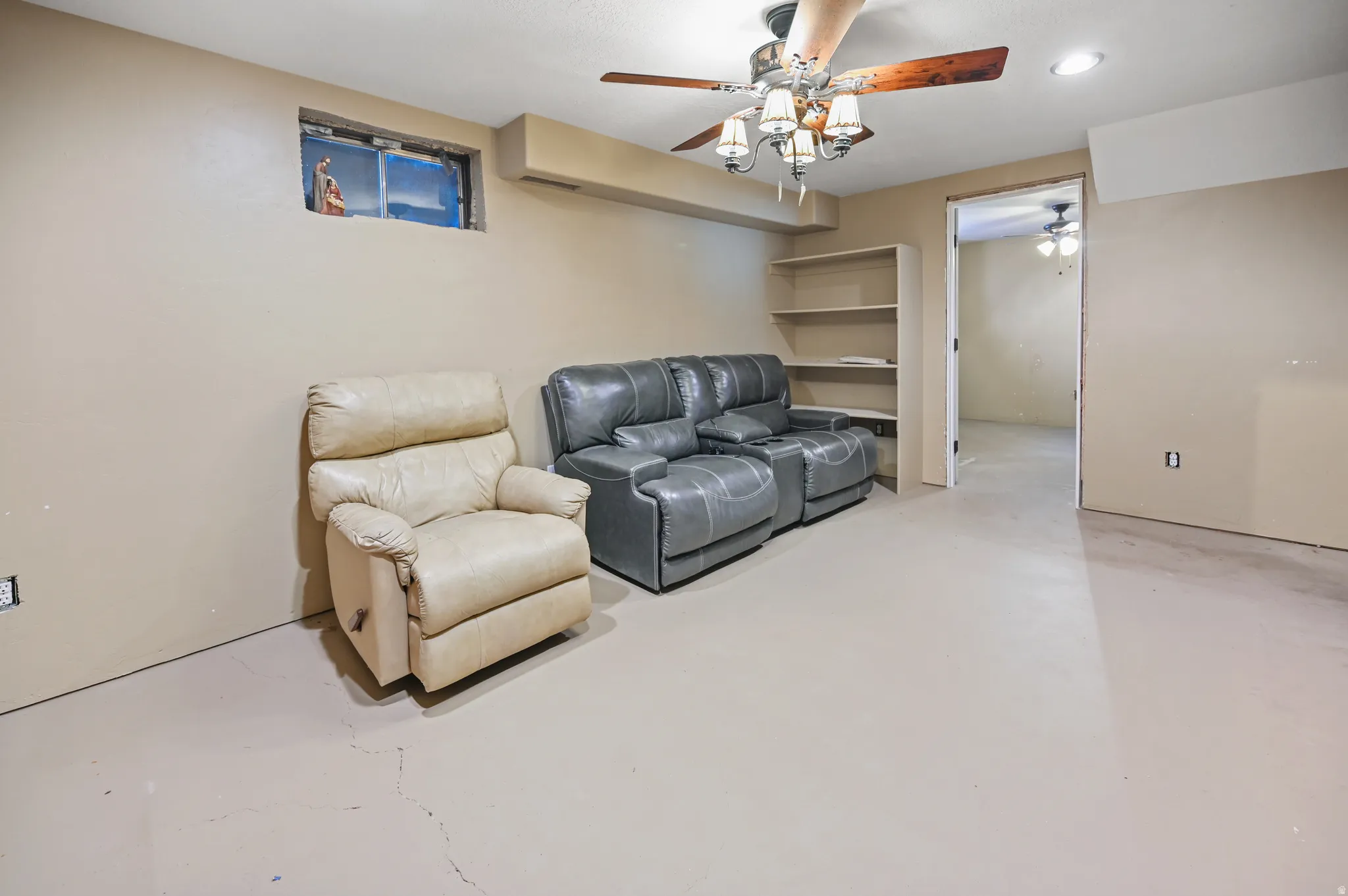 Sitting room with finished concrete flooring, a ceiling fan, and recessed lighting