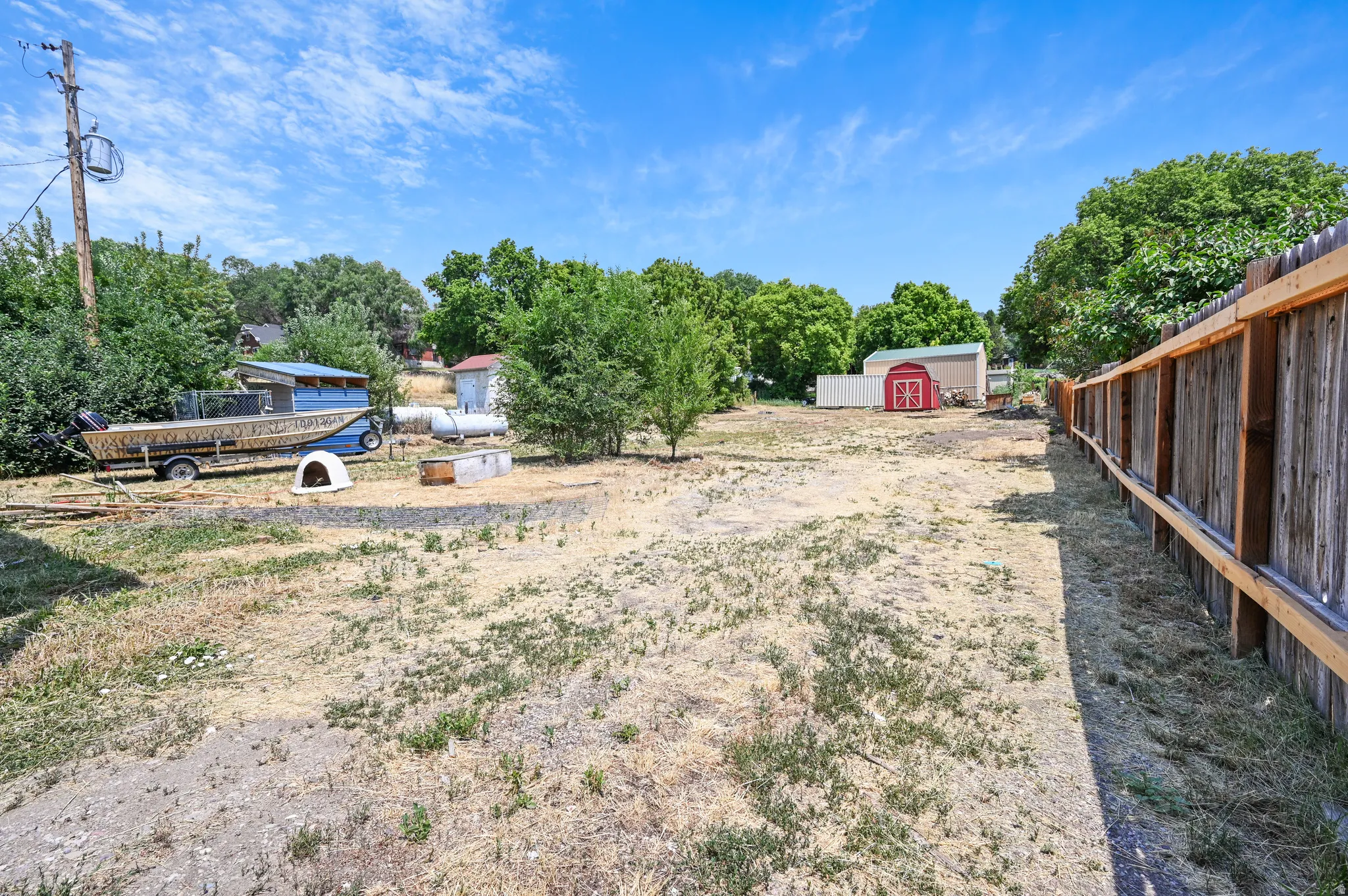 View of yard featuring view of wooded area and a storage shed