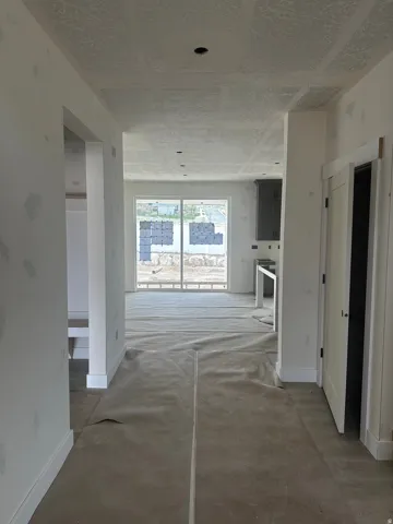 Hallway with baseboards and concrete floors