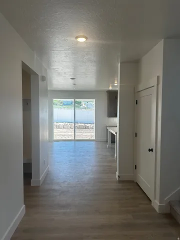 Wood-finish flooring extending throughout, with white trim and baseboards