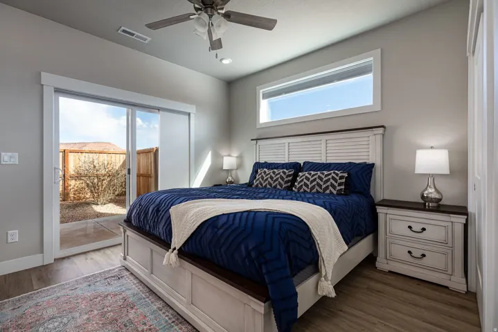 Bedroom featuring access to outside, wood finished floors, and a ceiling fan