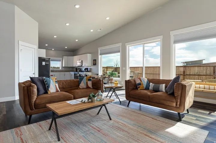 Living room with wood finished floors, lofted ceiling, and recessed lighting