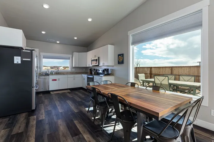 Dining room featuring vaulted ceiling, dark wood-type flooring, and recessed lighting