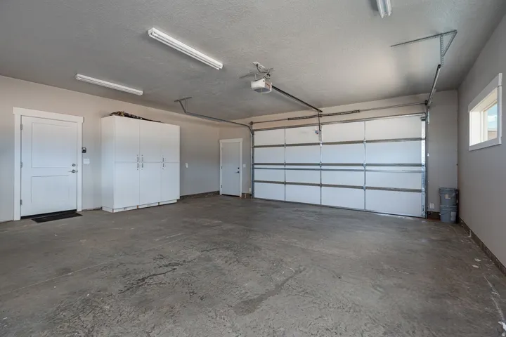 Garage featuring baseboards and a garage door opener