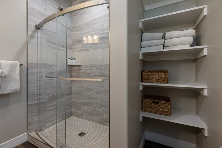 Full bath with a stall shower and baseboards