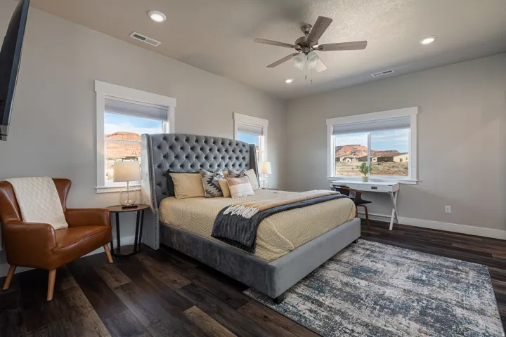 Bedroom featuring dark wood-type flooring, a ceiling fan, multiple windows, and recessed lighting