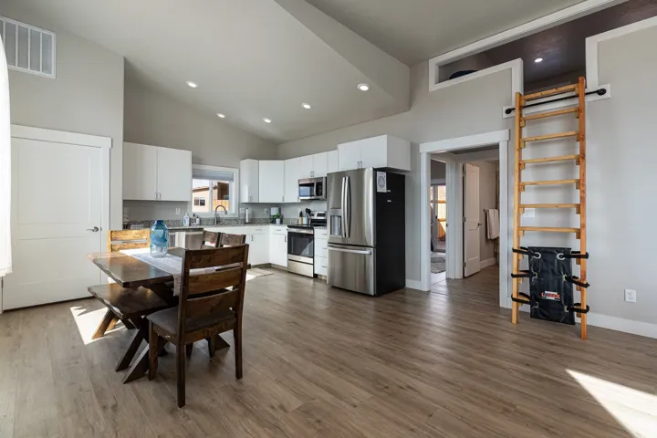 Dining space featuring dark wood-style flooring, recessed lighting, and lofted ceiling