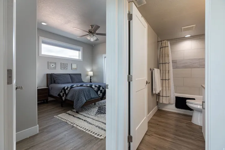 Bedroom with dark wood-style flooring, a ceiling fan, recessed lighting, and a textured ceiling