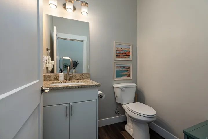 Half bath with vanity and dark wood finished floors