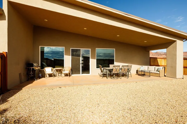 Rear view of property with a fenced backyard, a patio, stucco siding, and outdoor lounge area
