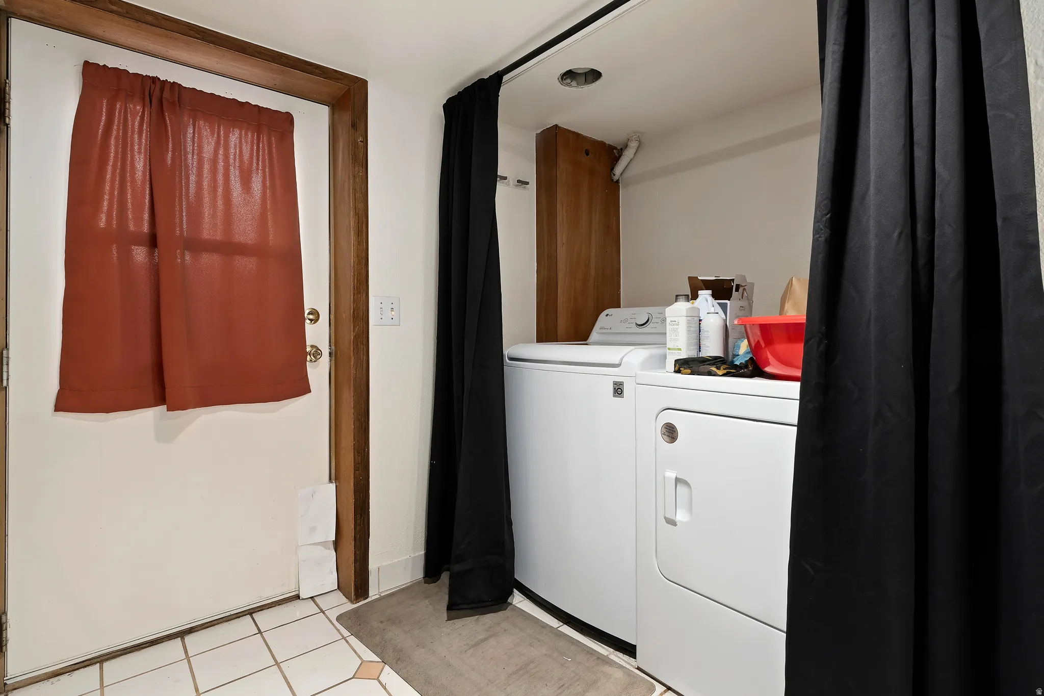 Laundry area featuring washing machine and dryer and light tile patterned flooring