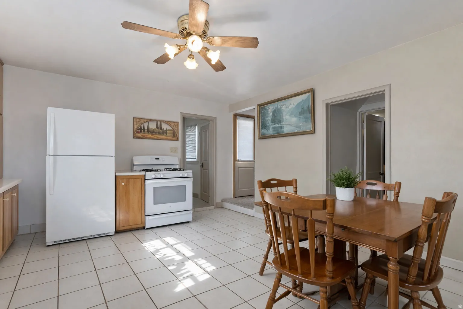 Dining space featuring a ceiling fan and light tile patterned flooring