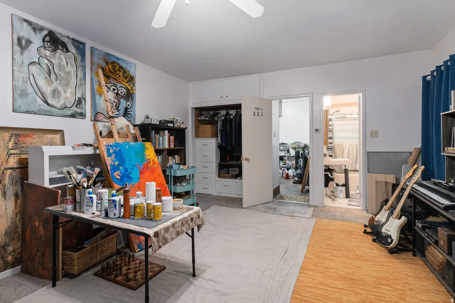 Office with light carpet and a ceiling fan
