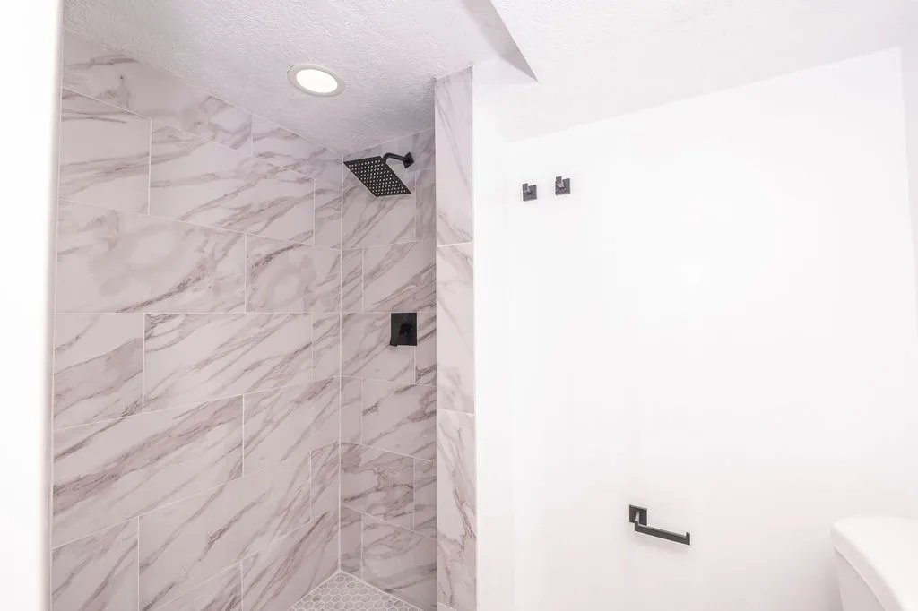 Full bath featuring a stall shower and a textured ceiling