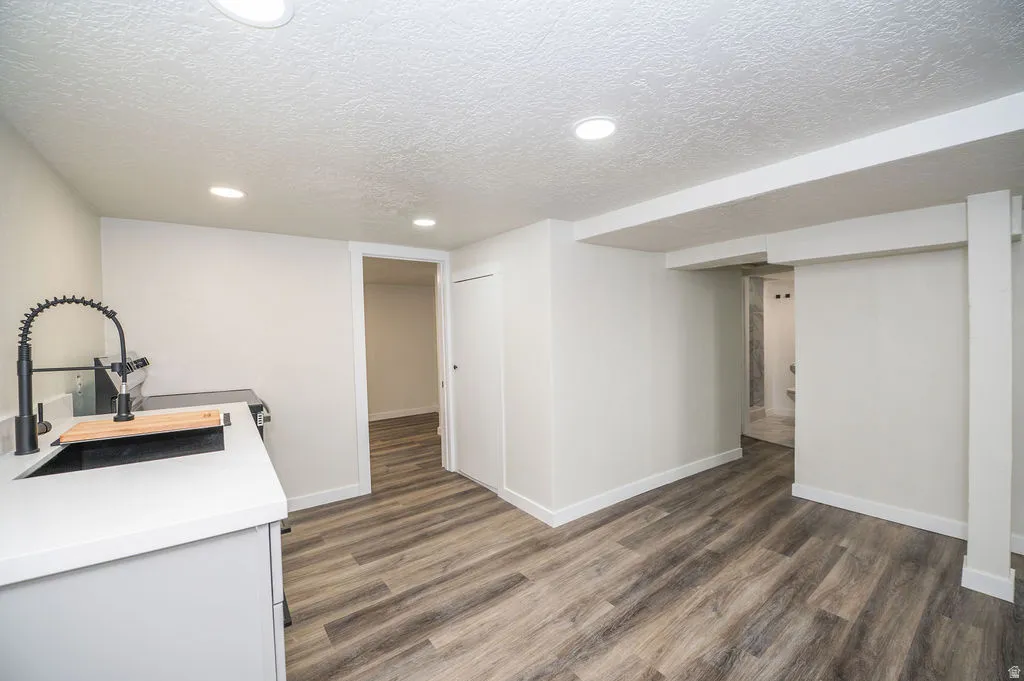 Kitchen featuring a textured ceiling, dark wood-type flooring, recessed lighting, and white cabinets