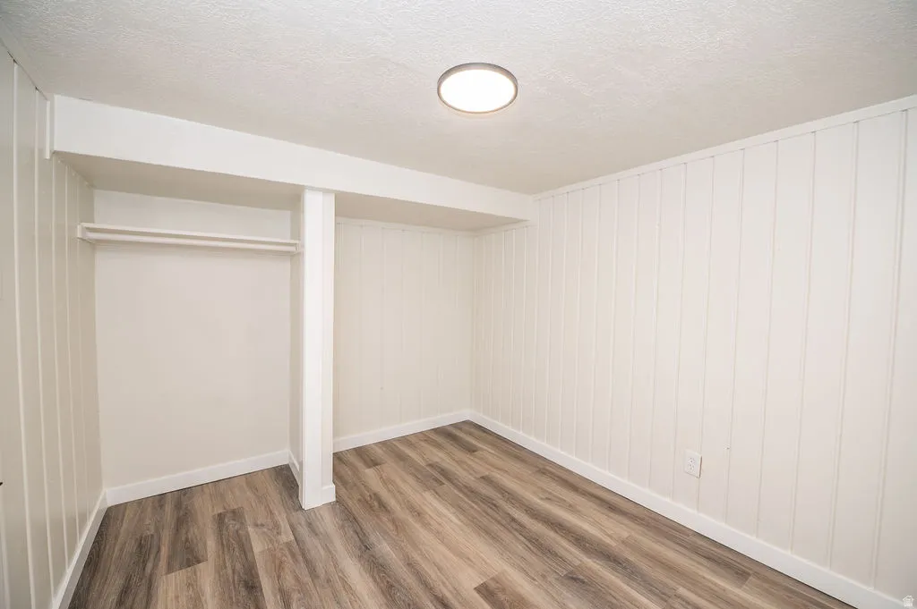 Unfurnished bedroom with wood finished floors, a textured ceiling, and a closet