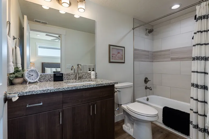 Bathroom featuring shower / tub combo, vanity, dark wood-style floors, recessed lighting, and a textured ceiling