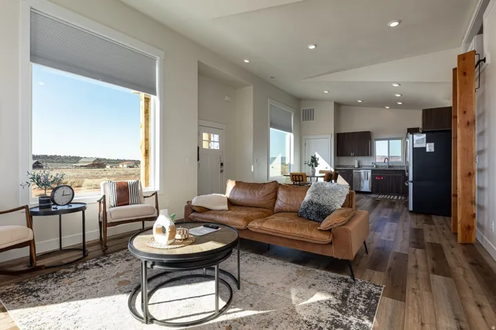 Living area with dark wood finished floors, lofted ceiling, and recessed lighting