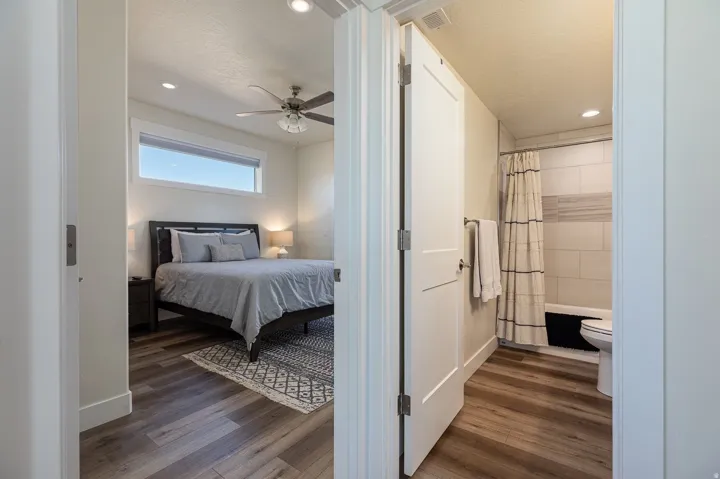 Bedroom with recessed lighting, dark wood-style floors, a ceiling fan, and ensuite bath