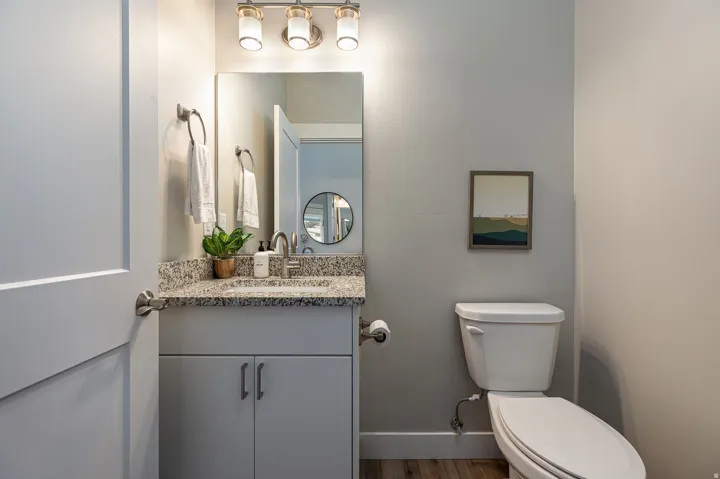 Half bath featuring vanity and wood finished floors