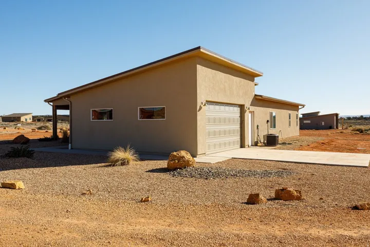 View of side of home with stucco siding, concrete driveway, and an attached garage