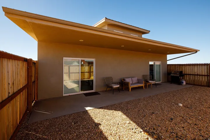 Rear view of house featuring a patio, a fenced backyard, and stucco siding