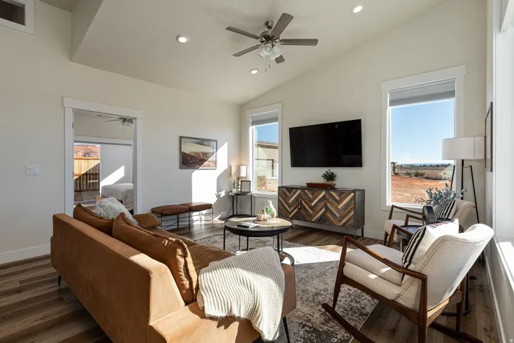 Living area with a ceiling fan, dark wood-style flooring, recessed lighting, and vaulted ceiling