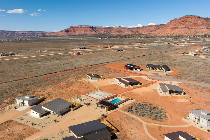 Aerial view of sparsely populated area featuring property boundaries highlighted and nearby suburban area