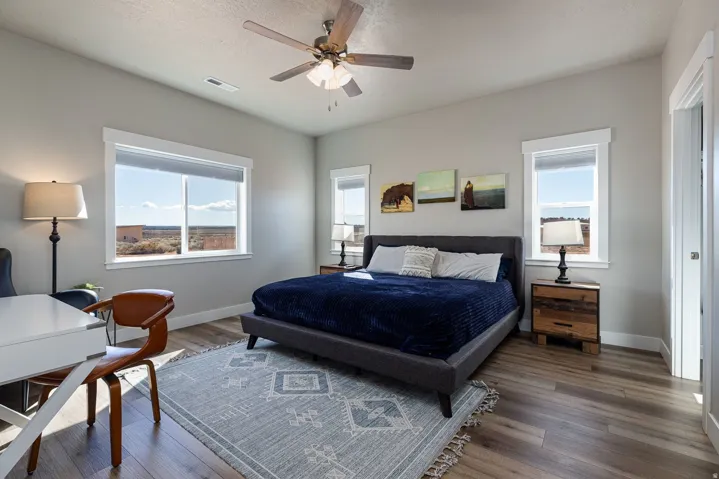 Bedroom with wood finished floors, ceiling fan, and a textured ceiling