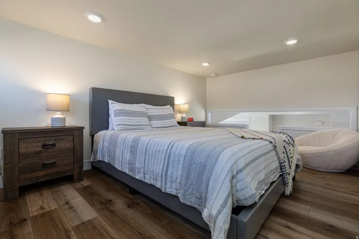 Bedroom with dark wood finished floors and recessed lighting