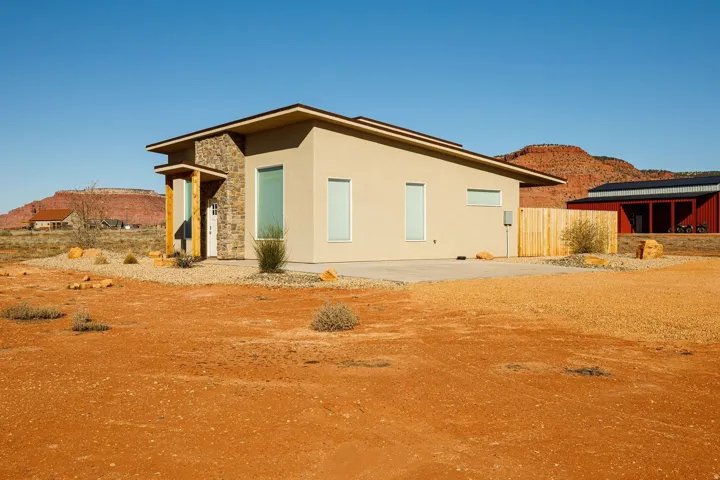View of side of home with stucco siding, stone siding, and a mountain view