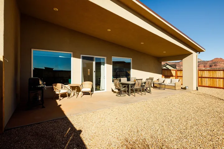 Back of property featuring a patio area, stucco siding, a fenced backyard, a mountain view, and an outdoor living / dining area
