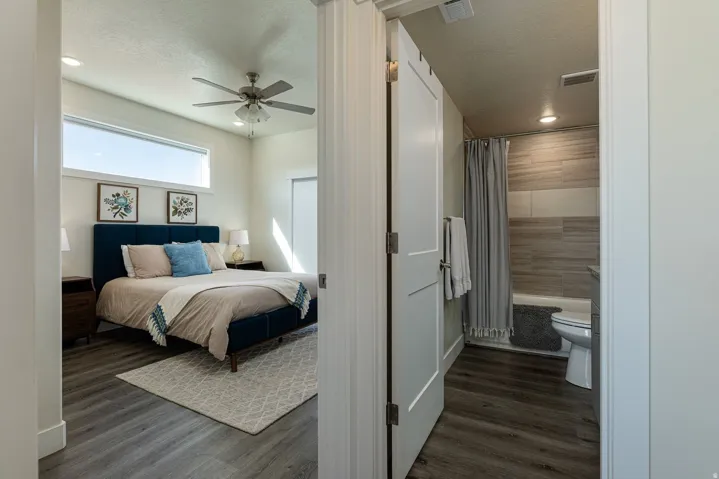 Bedroom featuring dark wood-type flooring, a ceiling fan, recessed lighting, a textured ceiling, and ensuite bathroom