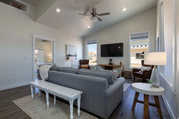 Living area with a ceiling fan, dark wood-type flooring, recessed lighting, and vaulted ceiling