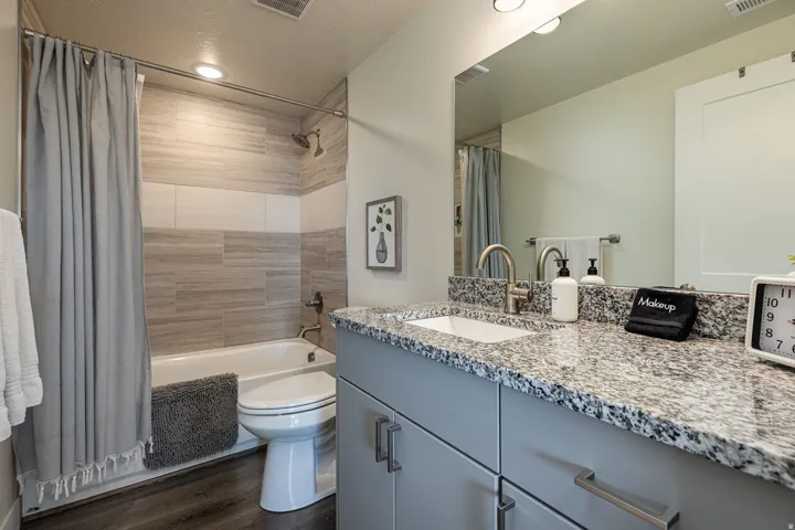 Full bathroom featuring vanity, shower / tub combo, dark wood finished floors, and recessed lighting