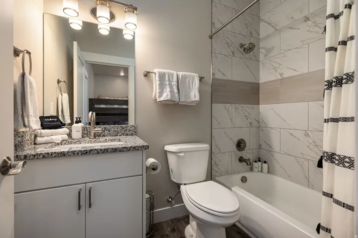 Full bathroom with shower / tub combo with curtain, vanity, and dark wood finished floors