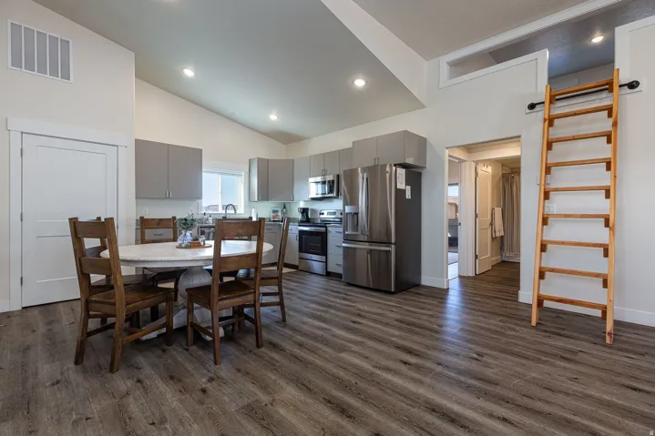 Dining room featuring dark wood-style flooring, recessed lighting, and lofted ceiling