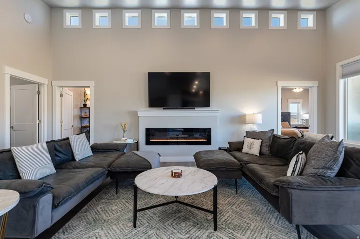Living area with a glass covered fireplace, a high ceiling, and wood finished floors